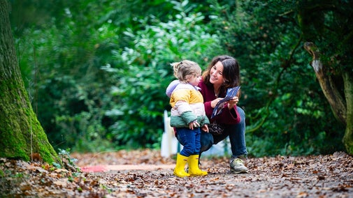 A young child and her mother look at a trail sheet in the Albana woodland at Ickworth Estate